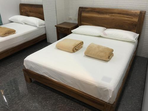卢塞纳Lucena Fresh Air Hotel的配有2张床的带白色床单和枕头的客房