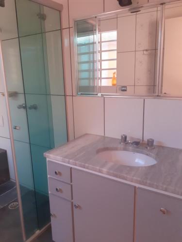 坎皮纳斯Franca Maya Hostel的一间带水槽和玻璃淋浴的浴室