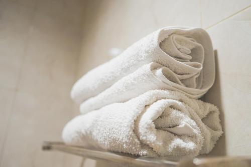 泗水City Residence Kutai 32的浴室架子上的一大堆毛巾