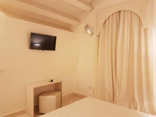 里杜德里伊斯坦西Hotel Azzurra的卧室配有一张床,墙上配有电视
