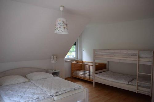 格赫伦-莱宾Ferienhaus Eichhörnchen am Fleesensee的一间卧室配有两张双层床和一张婴儿床。