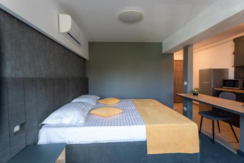 福克沙尼Corso Apartments B&B的一间带一张床和一张书桌的卧室和一间厨房