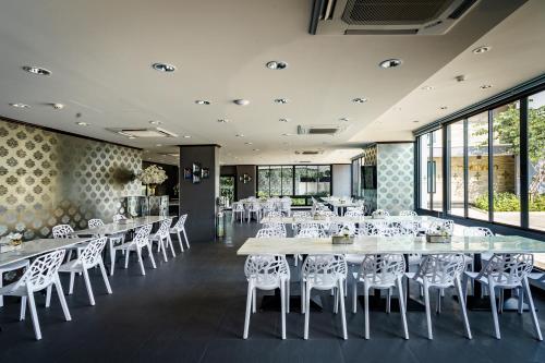 暖武里府Lux Boutique Hotel的用餐室配有桌子和白色椅子