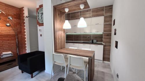 波兰尼卡-兹德鲁伊Lux Apartment Park的厨房配有白色橱柜和桌椅