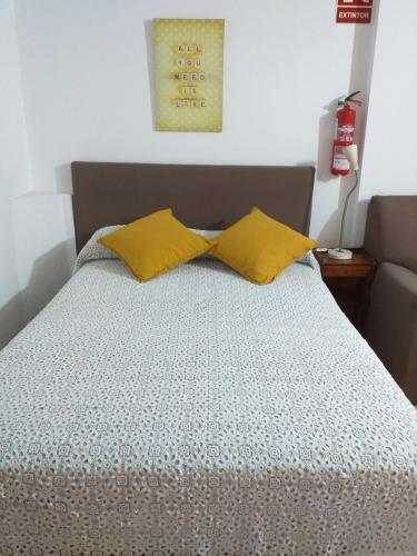 圣克鲁斯-德特内里费8 Calle Tangara La gloria的床上有两张黄色枕头