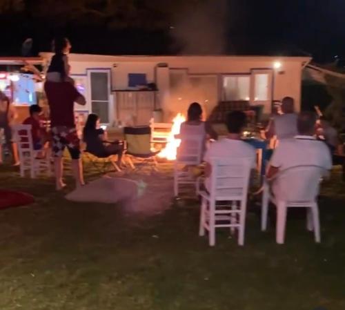 穆拉Bodrum Masali Camping的一群坐在椅子上,在火前的人