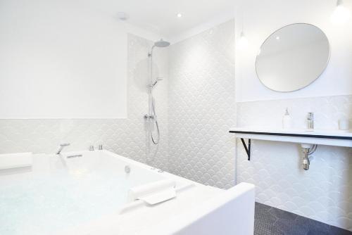 佩兹纳斯Maison 1634 - Centre historique, parking, petit-dejeuner compris, climatisation, piscine的白色的浴室设有浴缸和镜子