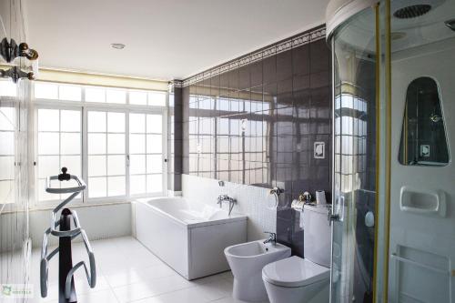 卡尔卡维洛斯Help Yourself Hostels - Carcavelos Coast的带浴缸、卫生间和盥洗盆的浴室