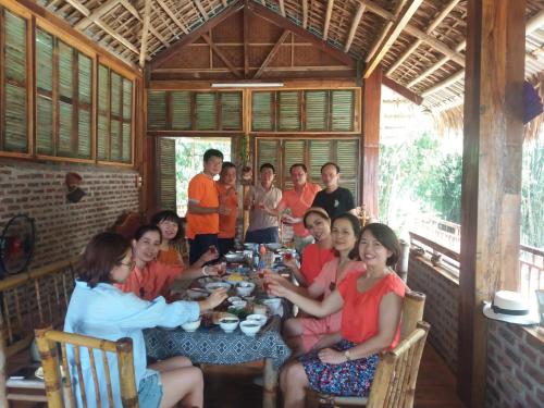 枚州县Mai Chau Xanh Bungalow的一群人坐在桌子旁