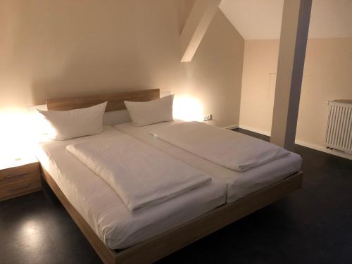 吕本瑙Ferienwohnung Zum Deutschen Hause的一间卧室配有带白色床单和枕头的床。