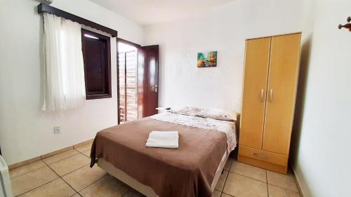 佩尼亚Hotel Praia Grande的一间带床和木柜的小卧室