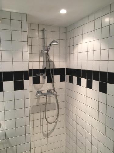 卑尔根Hotelroom Villa 1913的浴室铺有黑白瓷砖,设有淋浴。