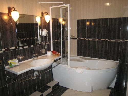 伊万诺-弗兰科夫斯克中庭酒店的带浴缸、水槽和浴缸的浴室