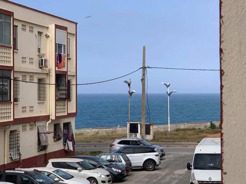 'Aïn TayaLes Falaises的海边停车场,有车停放