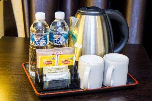 新山大世界酒店的一个带杯子和咖啡壶的托盘和瓶装水
