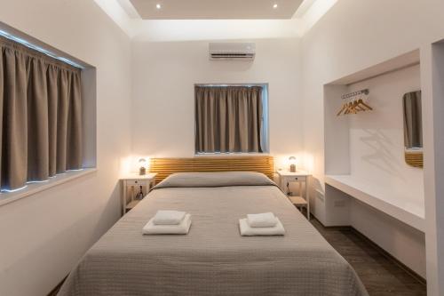 帕福斯Rooms - Unique staying in Paphos Centre的一间卧室配有一张床,上面有两条毛巾