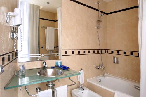 巴塞罗那埃文尼亚罗卡福特酒店的浴室配有盥洗盆和浴缸。
