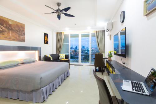 芭堤雅市中心Beautiful Apartment A6 Central Pattaya的一间卧室配有一张床和一张带笔记本电脑的书桌