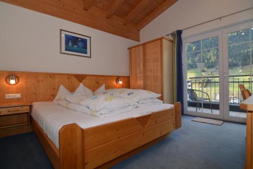 伊施格尔Garni Dorfblick的一间卧室设有一张木床和大窗户