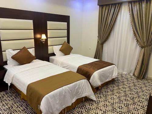 达曼دانة الشرقية للشقق المخدومة بالدمام Danat Al Sharqiah Serviced Apartments的一间酒店客房,房间内设有两张床