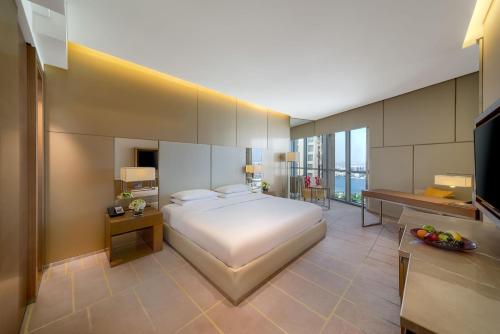 迪拜克里克高地凯悦公寓式酒店的一间大卧室,配有一张床和一台电视