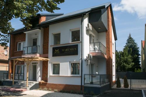 毛科Marusius Apartmanház的带有读取xyminders的标志的建筑