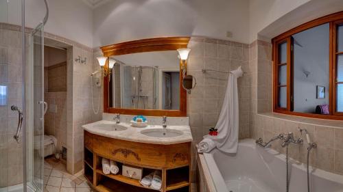 奥帕提亚Hotel Miramar的一间带水槽、浴缸和镜子的浴室