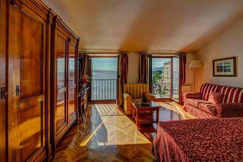 奥帕提亚Hotel Miramar的酒店客房带床、沙发和窗户