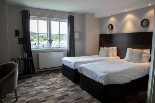 基尔赛斯The Boat House的酒店客房设有两张床和窗户。