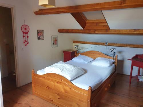 CombretDomaine du Plan del Poux Gîte rural的一间卧室配有一张带白色床单的木床