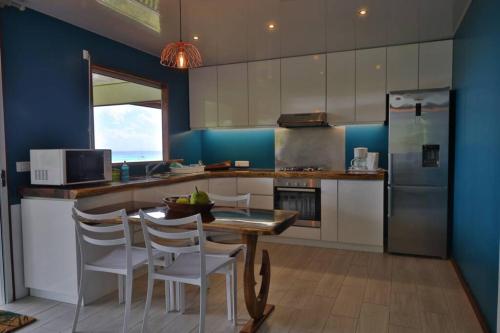 FitiiBienvenue au Mati House的厨房配有桌椅和冰箱。