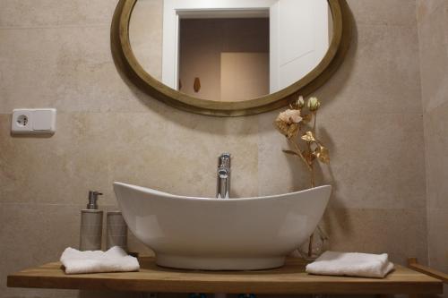 托莱多La Casa Toledana Estudio - Patio y Artesonado的浴室设有白色水槽和镜子