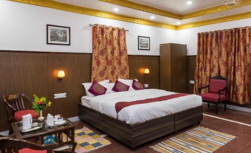 克久拉霍和谐酒店的酒店客房带一张床、一张桌子和椅子