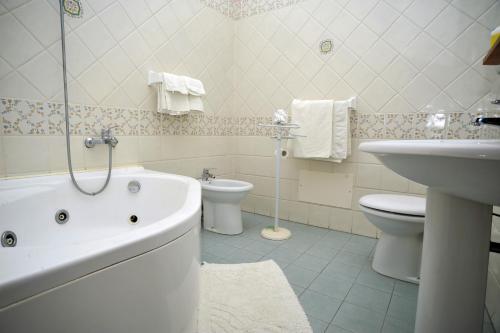 阿杰罗拉詹蒂莱酒店的带浴缸、卫生间和盥洗盆的浴室