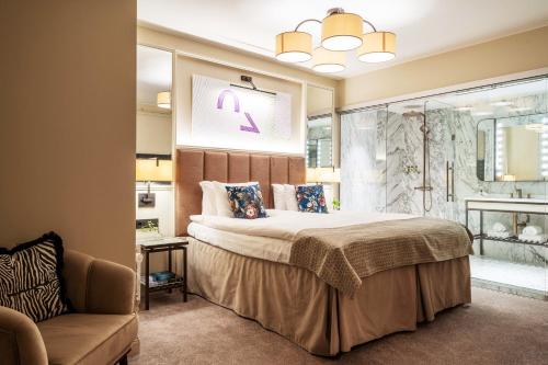 斯德哥尔摩Bank Hotel, a Member of Small Luxury Hotels的一间卧室配有一张大床和一把椅子