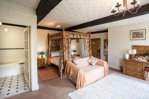 Longhope新屋农场住宿加早餐旅馆的一间卧室设有天蓬床和一间浴室。