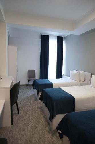 基希讷乌Glass Cube Hotel的酒店客房设有三张床和一张书桌
