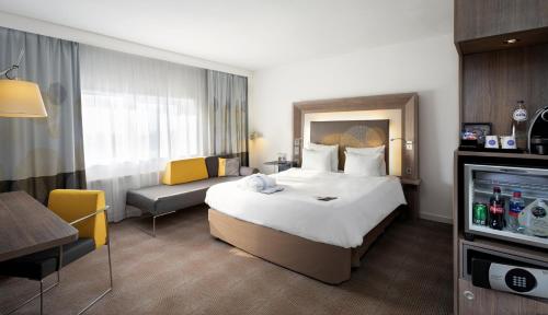 海牙海牙世界论坛诺富特酒店的酒店客房设有一张大床和一张沙发。