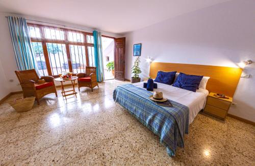 圣地亚哥港Villa Punta Negra HEATED POOL tenerifesummervillas的卧室配有一张床和一张桌子及椅子