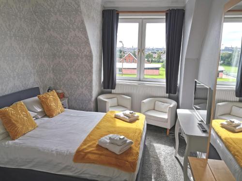 爱丁堡布利格欧东旅馆的小房间设有一张床、一张桌子和两个窗户