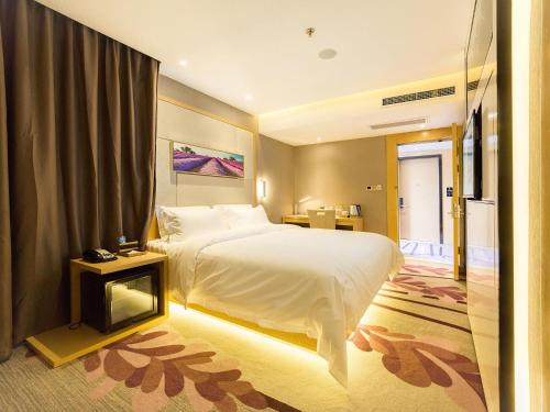 威海Lavande Hotels Weihai Weigao Square Branch的酒店客房,配有床和电视