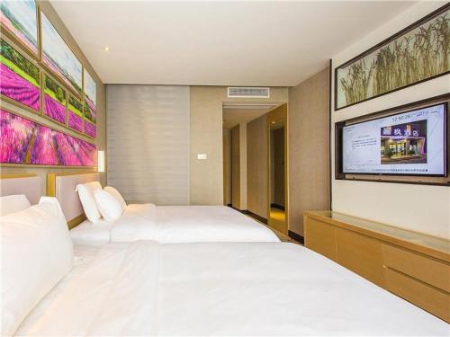 赣州丽枫酒店(黄金广场店) 的一间卧室配有两张床和一台平面电视