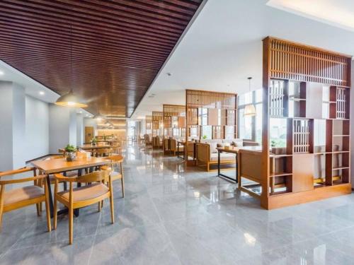 无锡Lavande Hotel Wuxi Taihu Avenue的大楼内带桌椅的用餐室