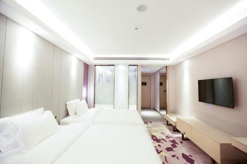 景德镇Lavande Hotel (Jingdezhen Taoxichuan Creative Square Branch)的酒店客房设有两张床和一台平面电视。