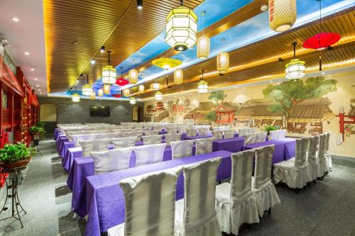 长沙Lavande Hotel Changsha Pedestrian Street Nanmenkou Metro Station Branch的宴会厅配有紫色和白色的桌椅