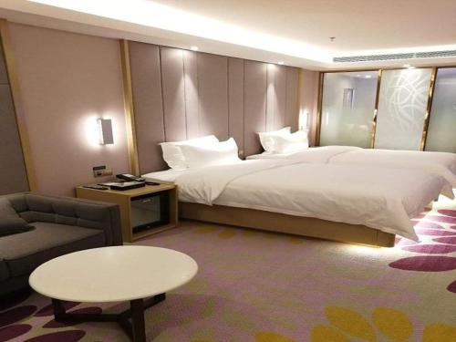 拉萨Lavande Hotel (Lhasa City Government Xizang University Branch)的酒店客房设有一张大床和一张桌子。