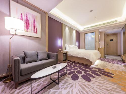 抚州Lavande Hotel (Fuzhou Wanda Branch)的酒店客房设有一张沙发和一张床