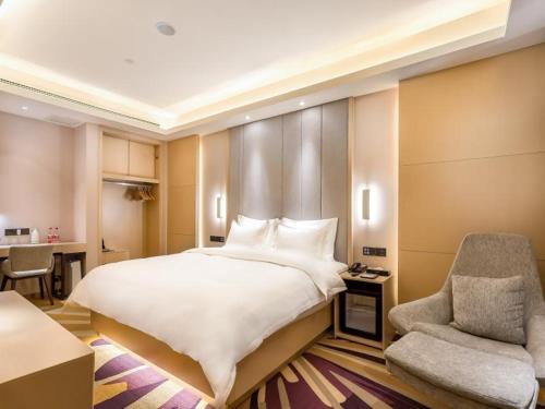 廊坊Lavande Hotel Langfang City Government的卧室配有一张白色大床和一把椅子