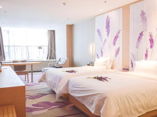 徐州Lavande Hotel Xuzhou New Town Midea Plaza的酒店客房配有两张床和一张书桌
