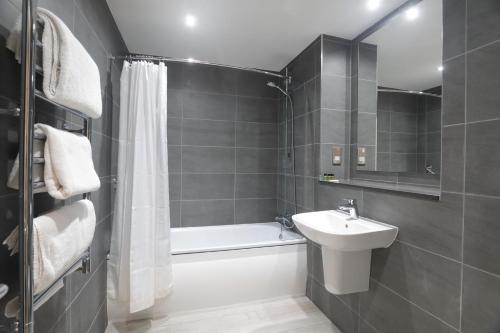 格伦科格兰库岛酒店的一间带水槽、浴缸和卫生间的浴室